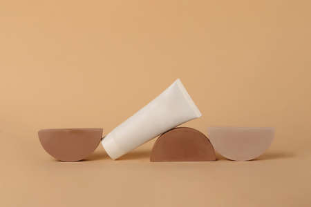 Cosmetic tube lies on the geometrical podiums.