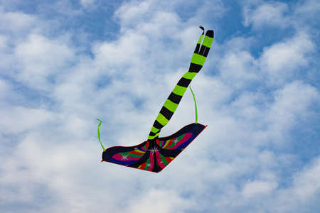 Colorful kite soaring on the blue cloudy sky.Summertime concept.Natural background.