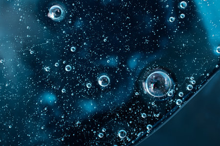 Liquid smear, cosmetics swatch on the blue background.Top view, antibacterial liquid surface.Good as...