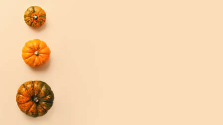 Three different sized pumpkins - from small to big on the beige background.Copy space for text,large...