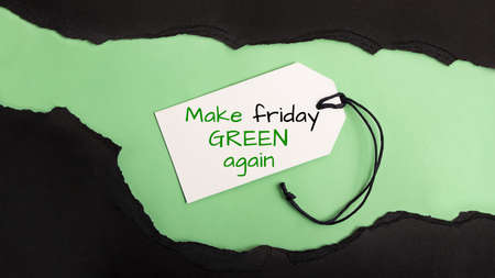 Torned paper on the green background.Call to action make black friday green again.Reducing excessive consumption.の写真素材