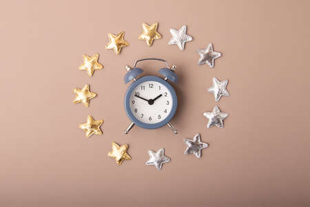 Alarm clock with golden and silver stars around it.Concept of the healthy dreams and circadian rhythms.の写真素材