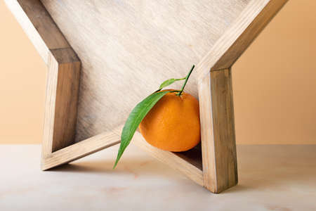 Composition from the fresh mandarin with green leaf on the wooden tray.Isometric beige background.Concept of the Christmas or family celebration.Copy space for text.の写真素材