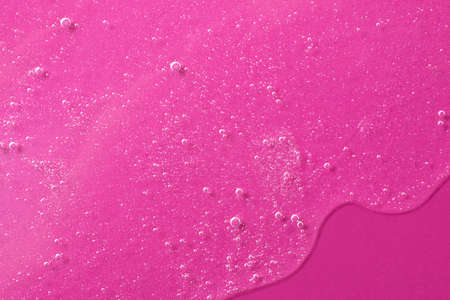 Background from cosmetic gel with bubbles, dripping down.Bright pink color, copy space for text or...