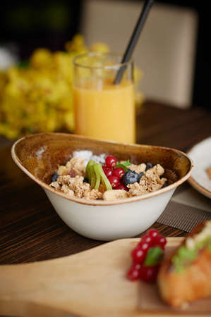 Dry breakfast with fresh berries,orange juice on background.Healthy meal,vertical photography.の写真素材