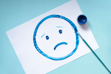 Top view of the drawing sad face.Blue monday and mental health concept.