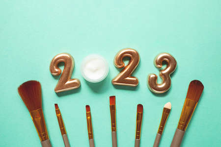 Top view of numbers 2022 with makeup brushes.Cosmetics banner for new year.