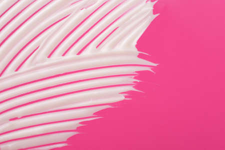 Abstract smear of white cosmetic cream on the pink background,abstract form.の写真素材