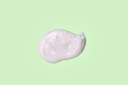Abstract smear of face srub on green background.