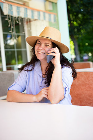 Happy stylish woman outside,making call via smartphone.Vertical photography.の写真素材