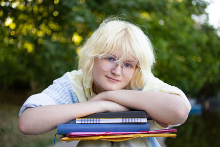 Vertical photography with teenage girl on the stadium.Student with folders.の写真素材