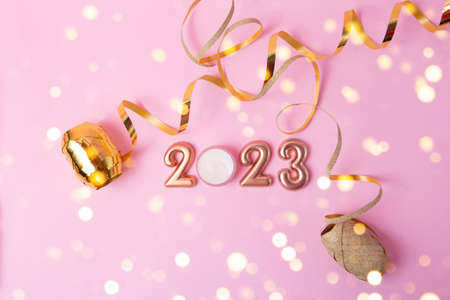 Top view of rose gold numbers 2023 on pink background.Festive confetti and sparlks around.の写真素材