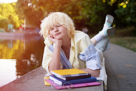 Photography with teenage girl,sleeping near the books and students folders.Sunlight on background.の写真素材