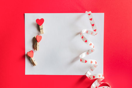 Blank greeting card with pins hearts on red and pink background. Mockup with copy space. Good for February 14.の写真素材