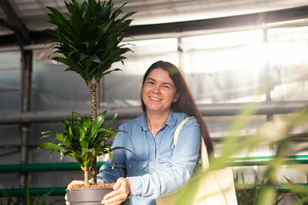 Cheerful woman holding yucca in her hands and smiling.の写真素材