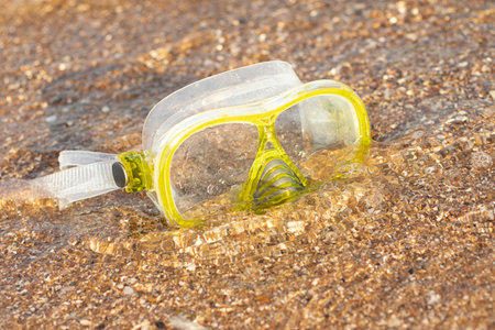 Close up photography of yellow snorkling mask standing in the sand.Underwater diving concept.の写真素材