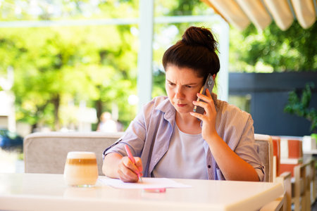 Serious bussines woman with smartphone,signed document.の写真素材