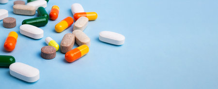 Front view of different pills on blue background, banner with negative space.の写真素材