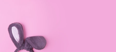 Top view of fluffy bunny rabbit ears on pink background.Easter minimal concept.Large banner with negative space.の写真素材