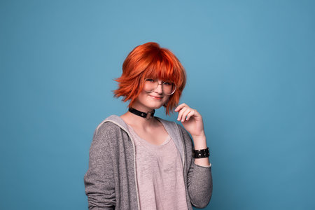 Portrait of stylish teenage girl with makeup on blue background.の写真素材