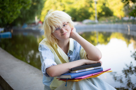 Cheerful teenage girl with several folders and notebook in hands.の写真素材