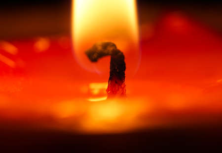 Macro shot of a burning candle on a black background with shallow depth of fieldの写真素材