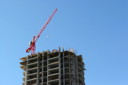 Crane and building construction site against blue skyのeditorial素材