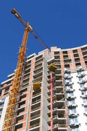 Crane and building construction site against blue skyのeditorial素材