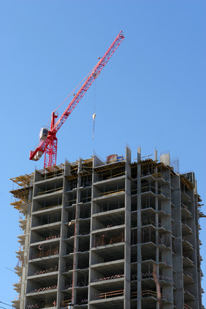 Crane and building construction site against blue skyのeditorial素材