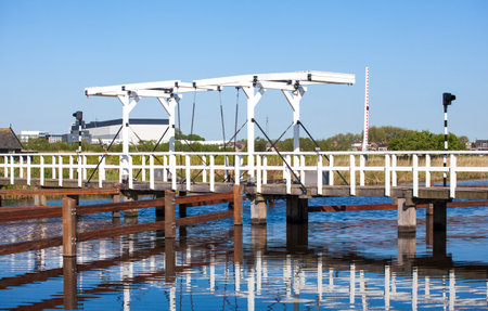 Traditional wooden drawbridge over a canal in the famous Dutch village of Kinderdijk, Hollandの写真素材