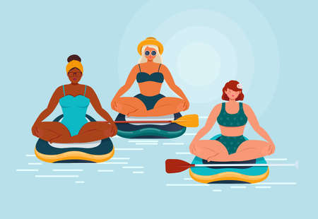 Young womens relaxing on a SUP boarding. Group of womens in swimsuits sit in lotus position on a...