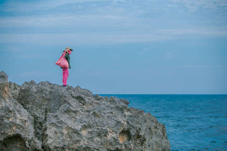 Woman picking up seaweed drifting in the sea. The place where the woman picks up the seaweed is Hang...
