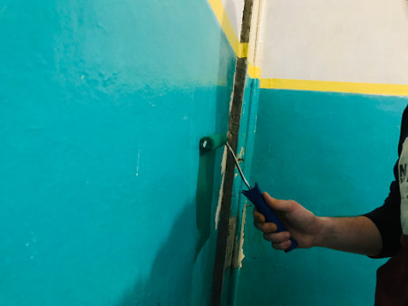A person paints a wall turquoise while renovating a room.の写真素材