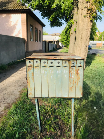 Old mailbox waits quietly by the roadside in spring.