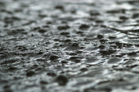 Bubbles on the surface of the flowing water during the rainの写真素材