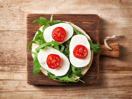 Fresh bagel sandwich on wooden table, top view
