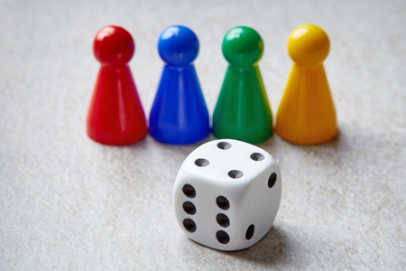 Colorful board game counters and dice on stone tableの写真素材