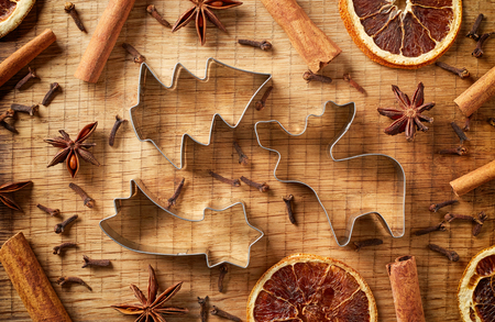 Christmas spices and cookie cutters on wooden background, top viewの写真素材