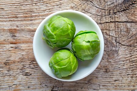 Bowl of Brussels sprouts on wooden background, top viewの写真素材