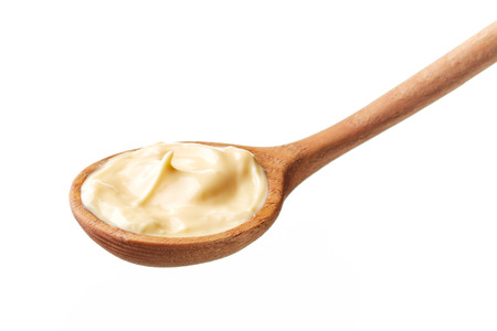 Mayonnaise in wooden spoon isolated on white backgroundの写真素材
