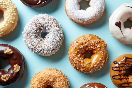 Various colorful donuts on blue background, top viewの写真素材