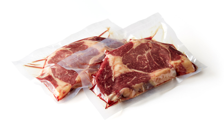 Beaf steak vacuum sealed ready for sous vide cooking isolated on white backgroundの写真素材