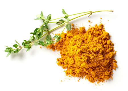 Heap of curry powder and a branch of rosemary isolated on white background, top viewの写真素材