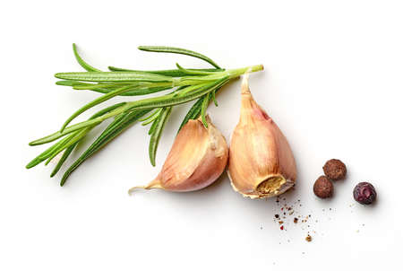 Garlic cloves with roesemary branch and black pepper isolated on white background; top viewの写真素材