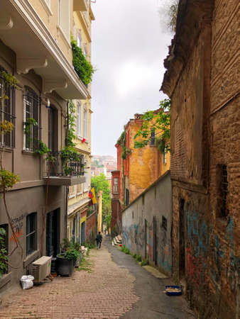 Empty downward side street of Istambul, Turkey with historical stone buildings and graffiti in early morning hours. Istambul, Turkey side street in early morningの写真素材