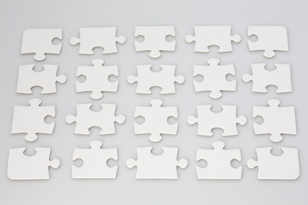 All white jigsaw puzzle with pieces symmetrically placed with space in between の写真素材