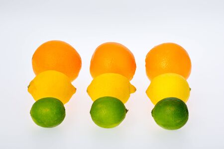 3 oranges, 3 lemons and 3 lime fruits aligned in 3 rows on white background の写真素材