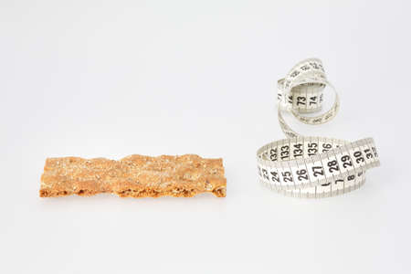 Weight loss concept with healthy dry bread and measuring tape  Isolated on white background の写真素材