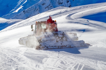 Heavy snow grooming machine preparing ski slopes in the Alps の写真素材
