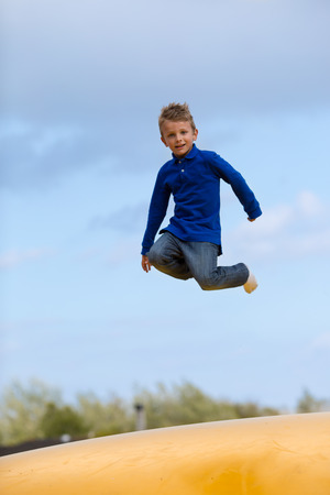 Boy jumping up and down on bouncy pad. の写真素材